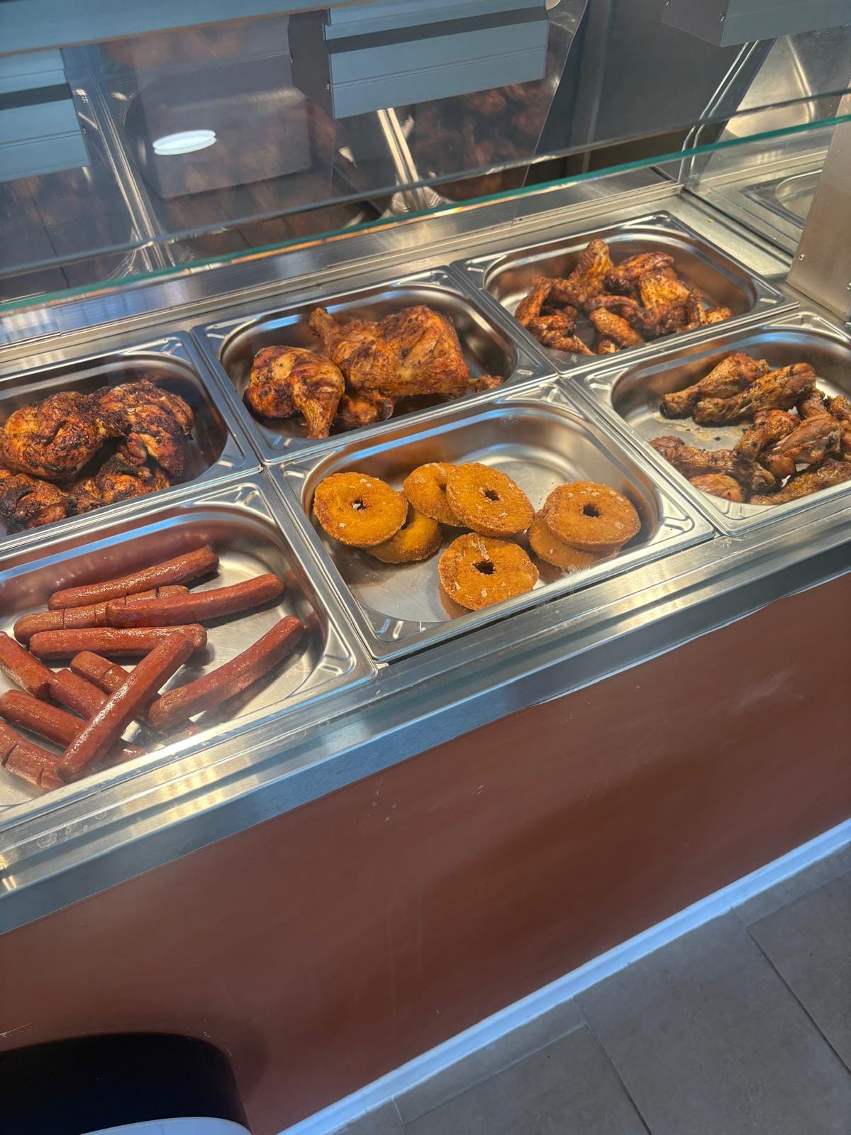 Vitrine garnie de poulets rôtis, ailes et chicken donuts chez Crousti Chef